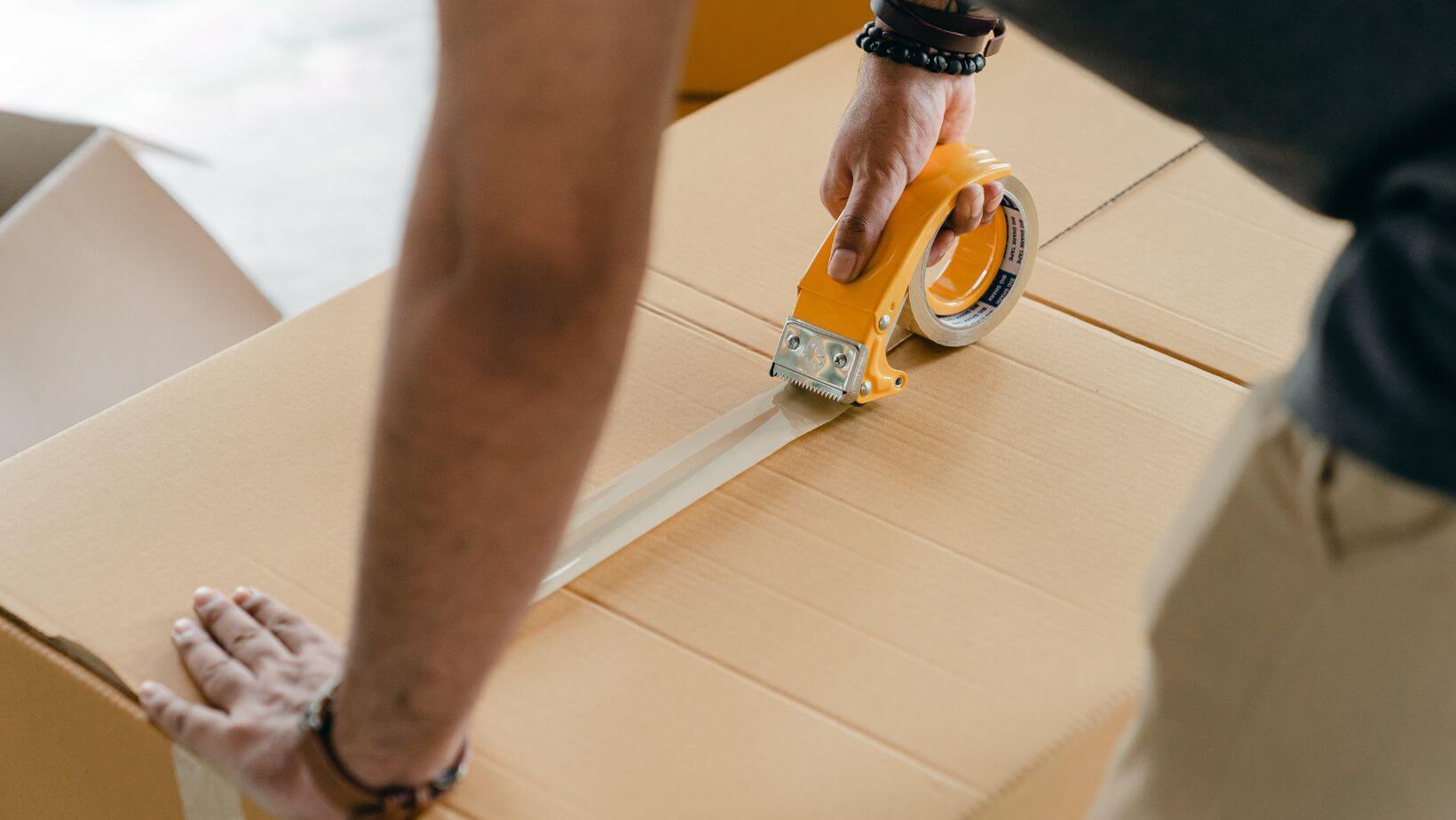 a man taping up a moving box