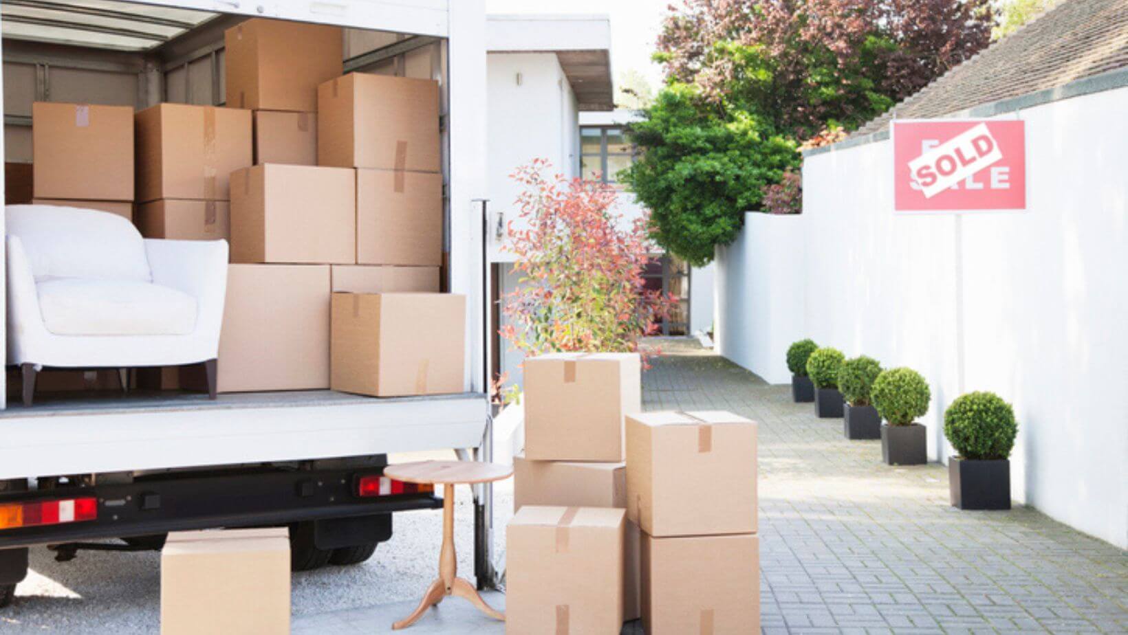 The back of a moving truck, showing the boxes and furniture inside.