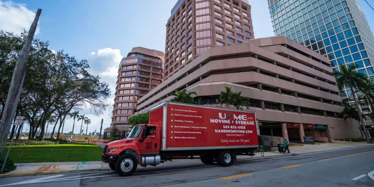 Red U & Me Moving truck parked downtown near office buildings, representing best way to move long distance with professional movers