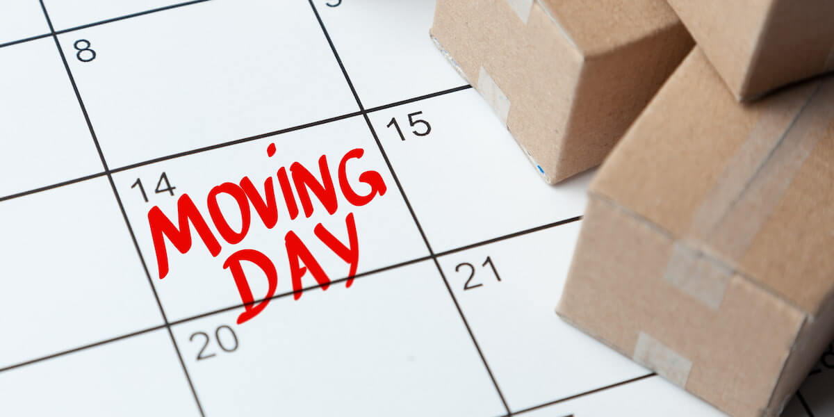 Calendar marked with “Moving Day” and cardboard boxes showing planning for when is the best time to move