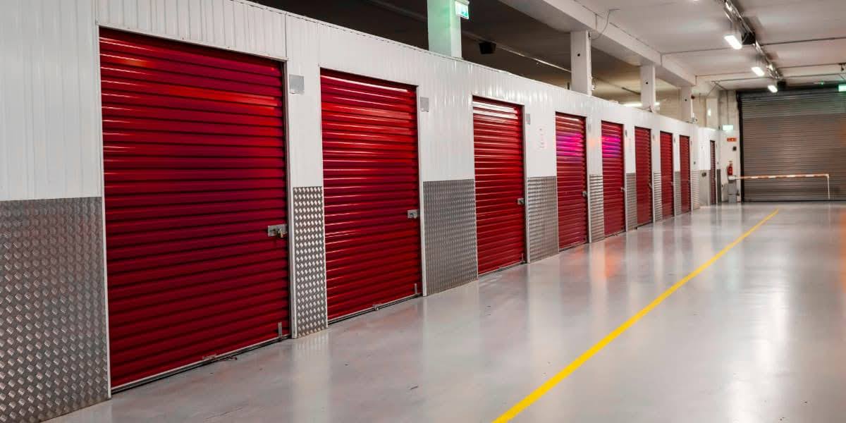 Indoor facility hallway with red doors showing storage spaces for pod vs storage unit comparison